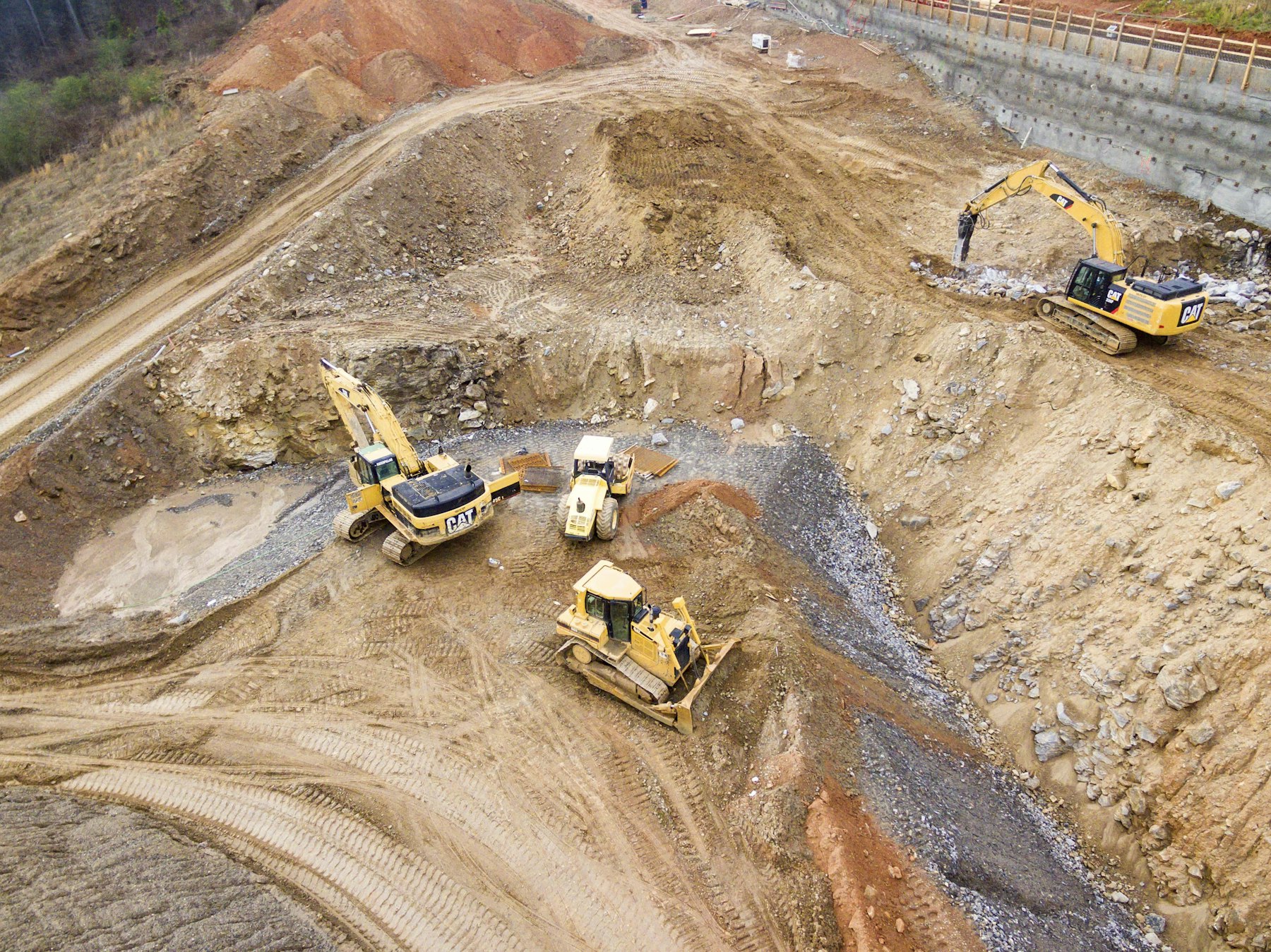 Aerial view of four heavy machines working in a quarry